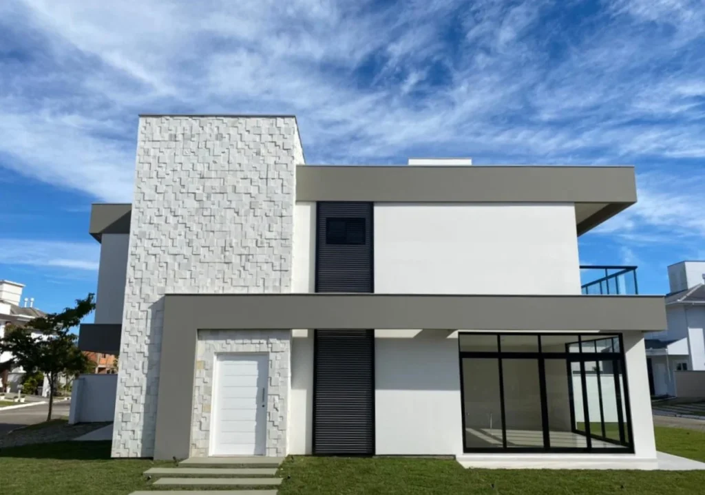 Foto da obra concluída, fachada lateral direita, com o painel de pedra e a laje em balanço