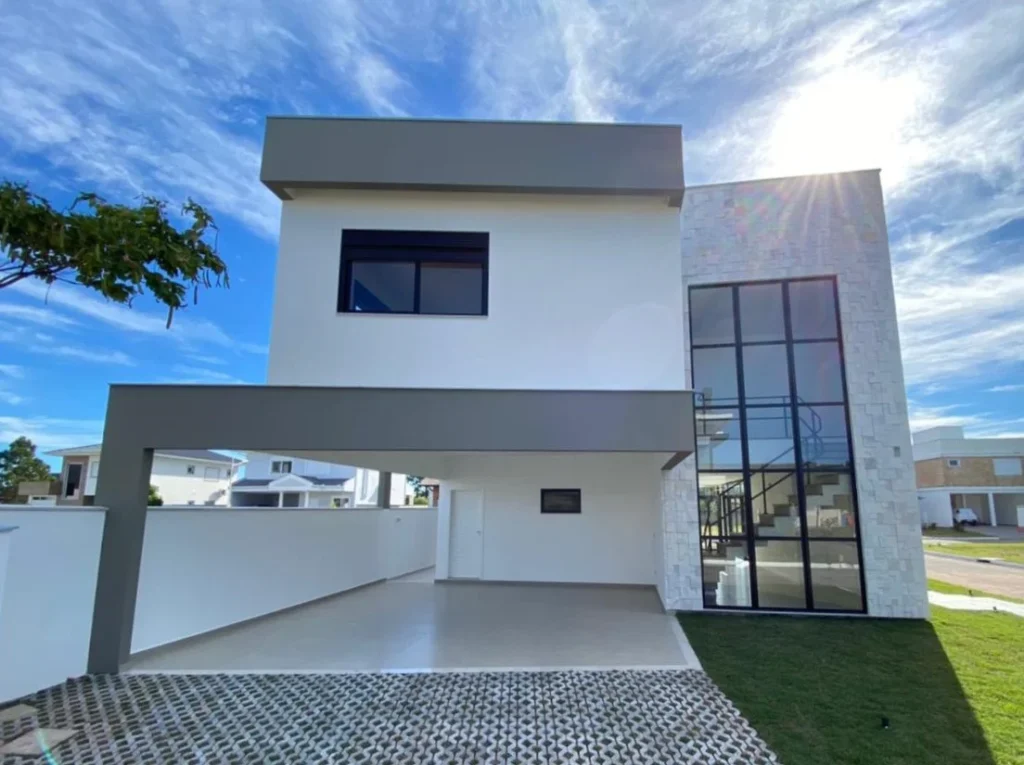 Foto da obra concluída, fachada frontal, com a laje avançando sobre o acesso