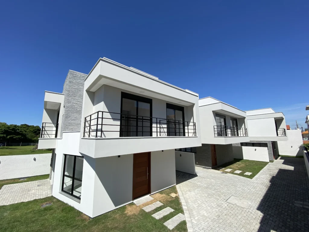Foto da obra concluída em perspectiva frontal, com as coberturas inclinadas e o acesso pavimentado
