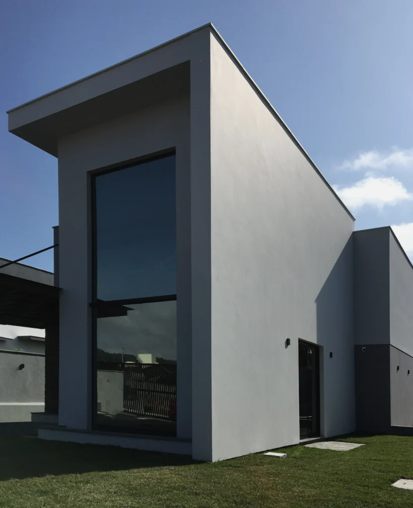 Foto da obra concluída em perspectiva frontal, mostrando o volume compacto e a lateral cega