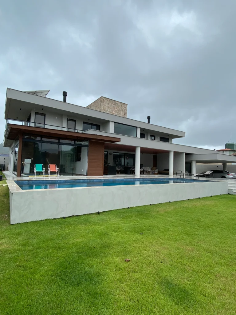 Foto da obra concluída vista de lado, com a piscina alinhada à frente e o muro de arrimo em branco