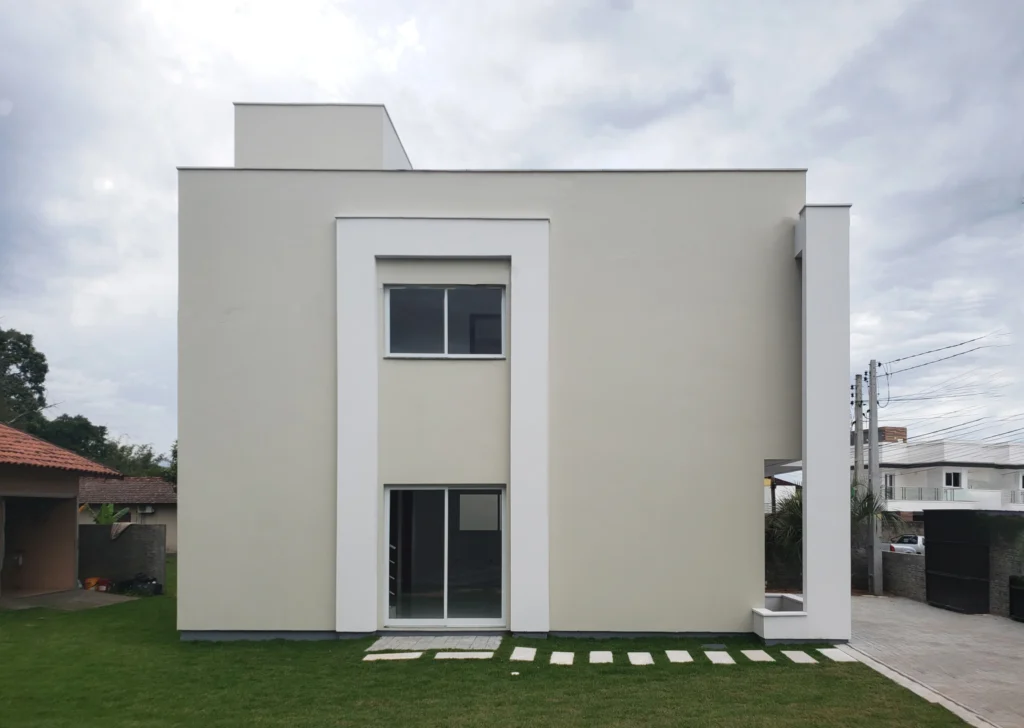 Fachada lateral de superfície lisa, com moldura vertical reunindo as janelas dos dois pavimentos