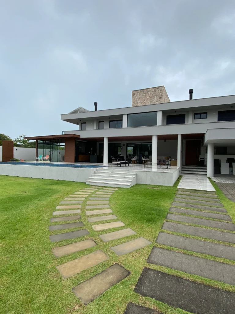 Foto da obra concluída em enquadramento aproximado, mostrando a escada de acesso ao terraço e a área social envidraçada