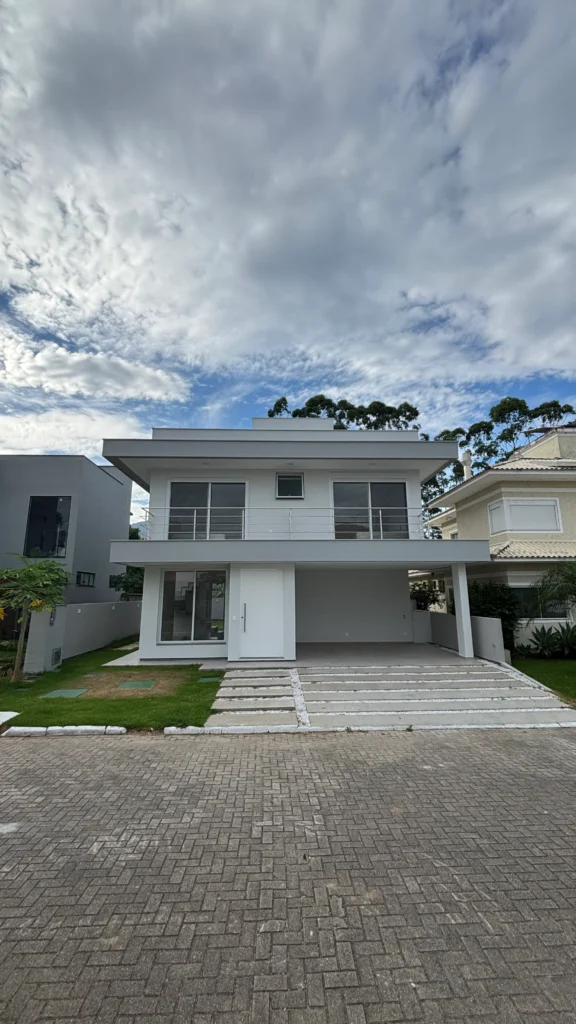 Foto da obra concluída, fachada frontal vista da rua, com o piso intertravado do acesso