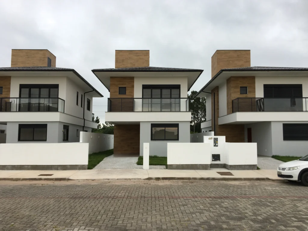 Foto da obra concluída, fachada frontal do conjunto, com os volumes de madeira acima das lajes